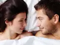 Para młoda leży w łóżku, patrząc na siebie z czułością. Czy to ich seks na pierwszej randce?