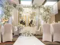 Elegancka sala weselna z białymi kwiatami i złotymi lustrami. Idealne miejsce, by zorganizować przyjęcie po ślubie cywilnym.