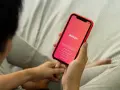 Osoba trzyma telefon z aplikacją Tinder. Zastanawiasz się, czy warto założyć Tindera? Może to początek nowej znajomości.