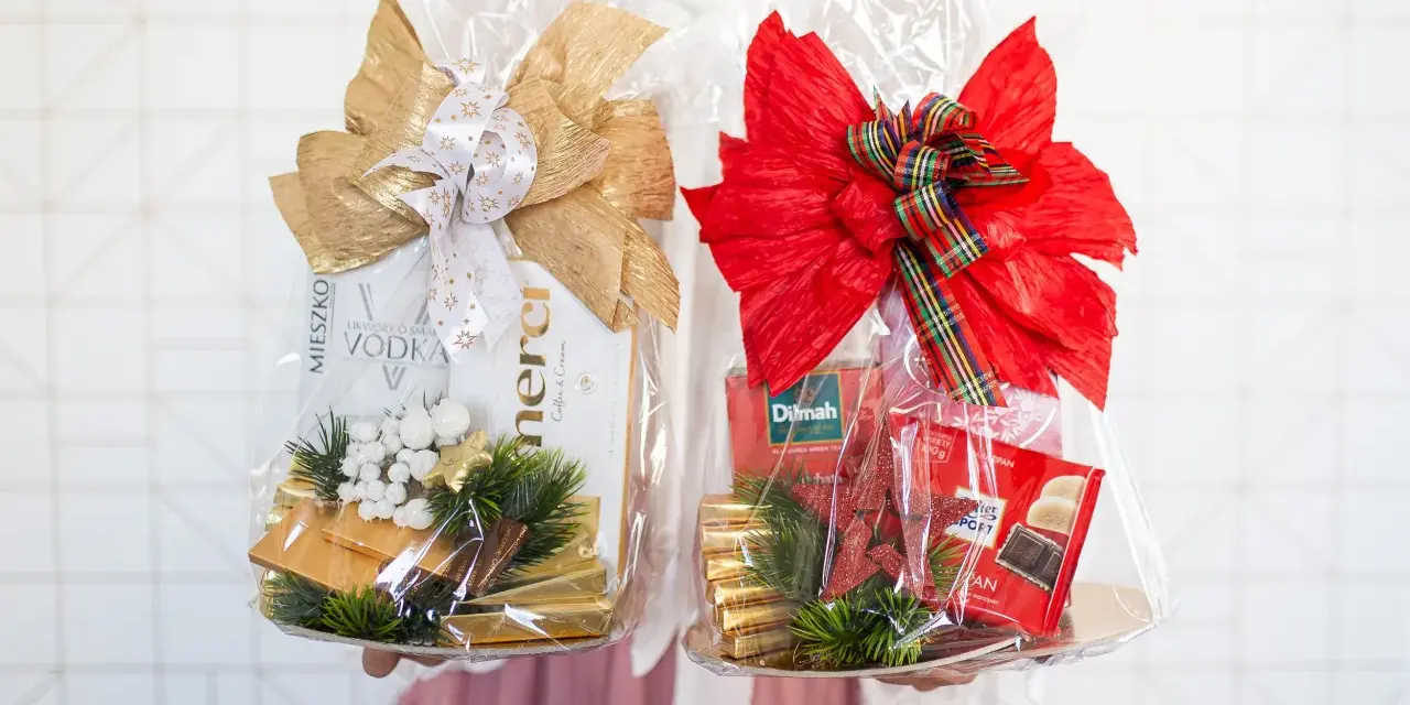 Dwa eleganckie kosze prezentowe z alkoholem, kawą i czekoladkami. Idealne podziękowania dla rodziców, kosze co włożyć, by sprawić im radość.