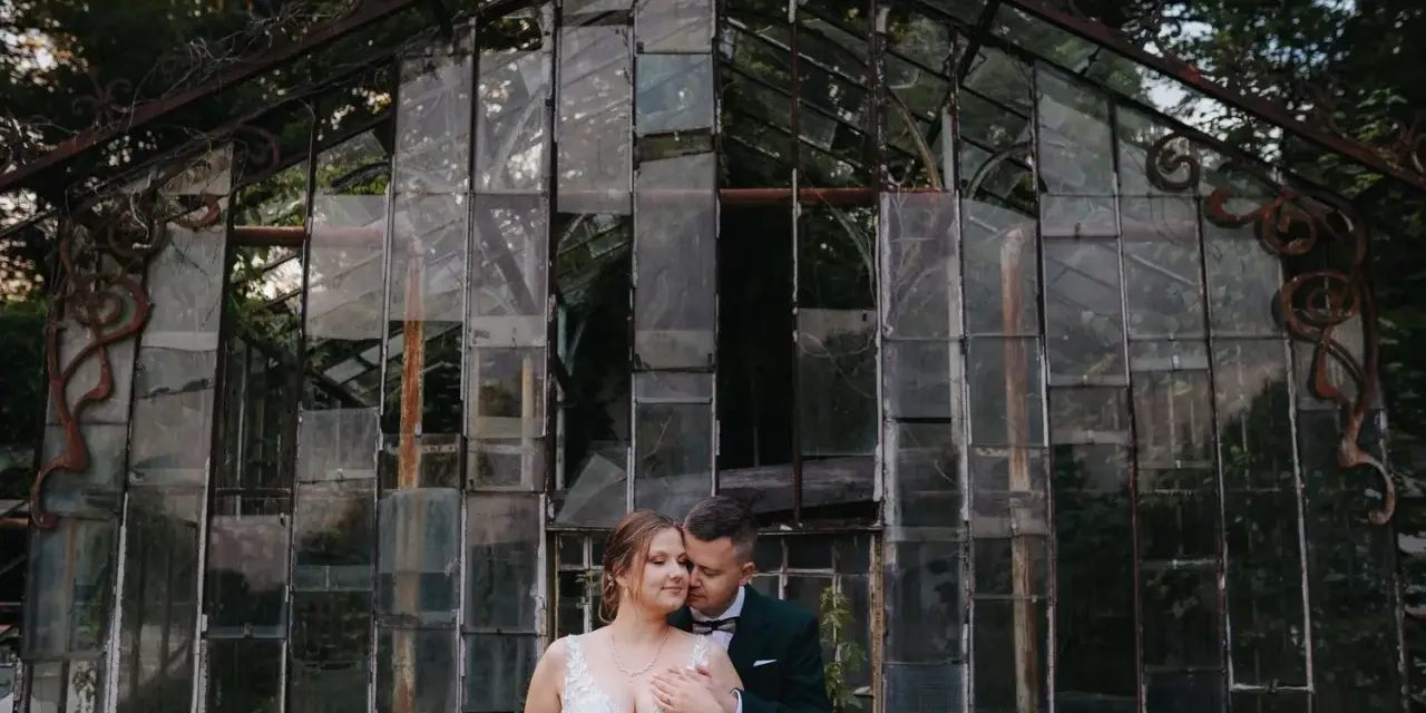 Para młoda przed zniszczoną szklarnią. Czy ślub w lipcu przesądy mają znaczenie?