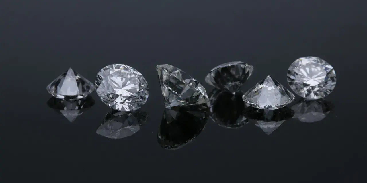 Siedem błyszczących diamentów na czarnym tle. Co oznacza diament na sympatii? Symbol trwałości i piękna, jak te kamienie.