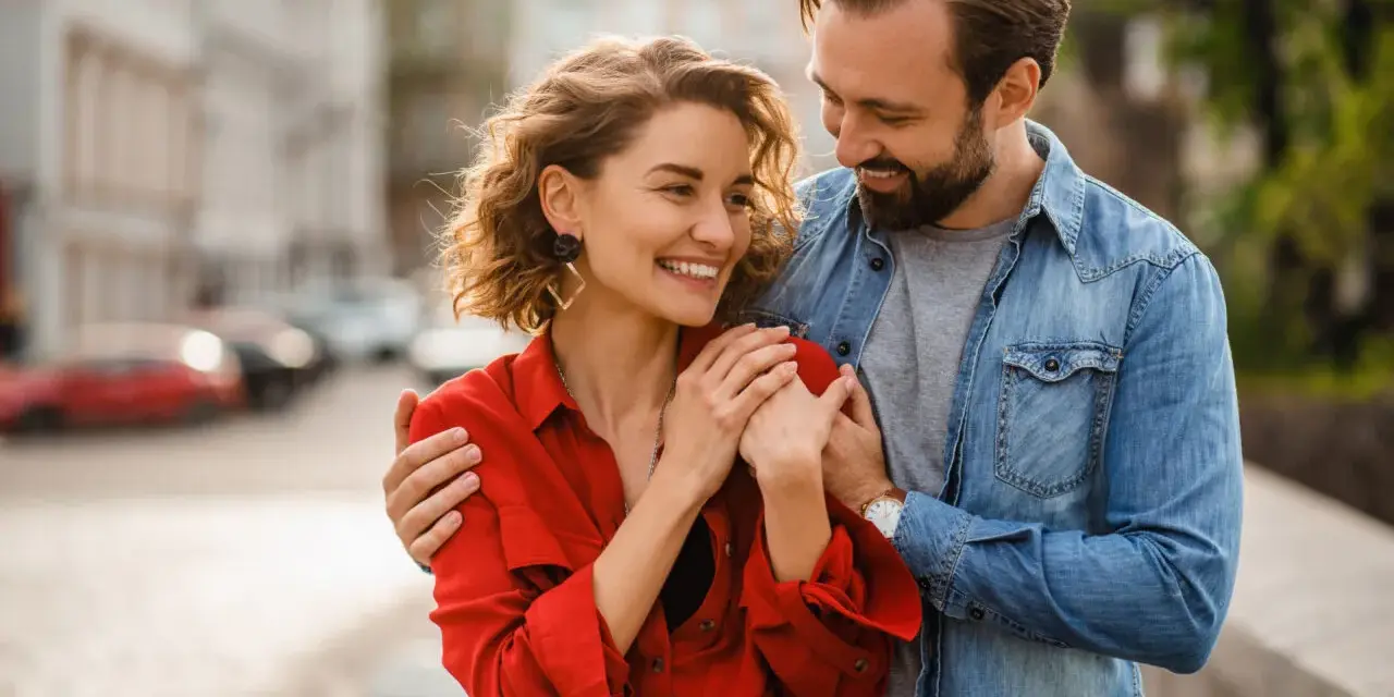 Uśmiechnięta para, on obejmuje ją ramieniem. Czy to oznaki flirtu w pracy, czy początek czegoś więcej?
