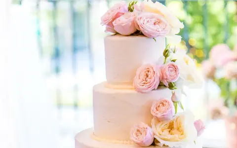 Elegancki tort weselny glamour ozdobiony delikatnymi różowymi i kremowymi różami.