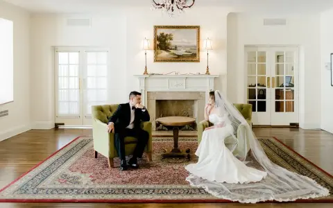 Para młoda w eleganckich strojach siedzi naprzeciwko siebie, rozmawiając o tym, co daje ślub cywilny.