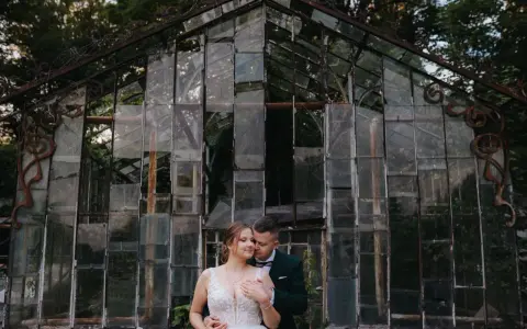 Para młoda przed zniszczoną szklarnią. Czy ślub w lipcu przesądy mają znaczenie?