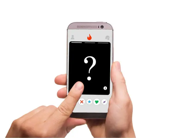 Dłoń trzyma smartfon z aplikacją randkową. Na ekranie widnieje znak zapytania i ikony: X, gwiazdka, serce, błyskawica. To **Tinder oznaczenia** – decyzja należy do Ciebie!