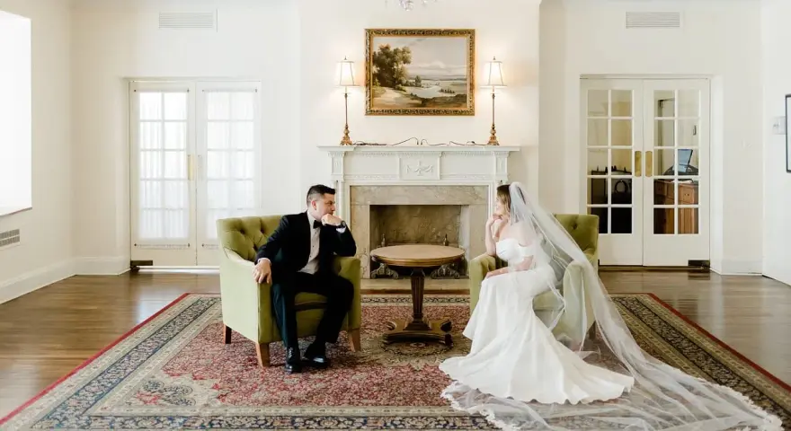 Para młoda w eleganckich strojach siedzi naprzeciwko siebie, rozmawiając o tym, co daje ślub cywilny.