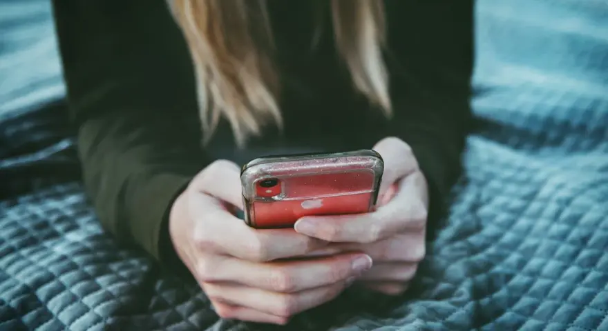 Dziewczyna przegląda profile na Tinderze, szukając dopasowania.