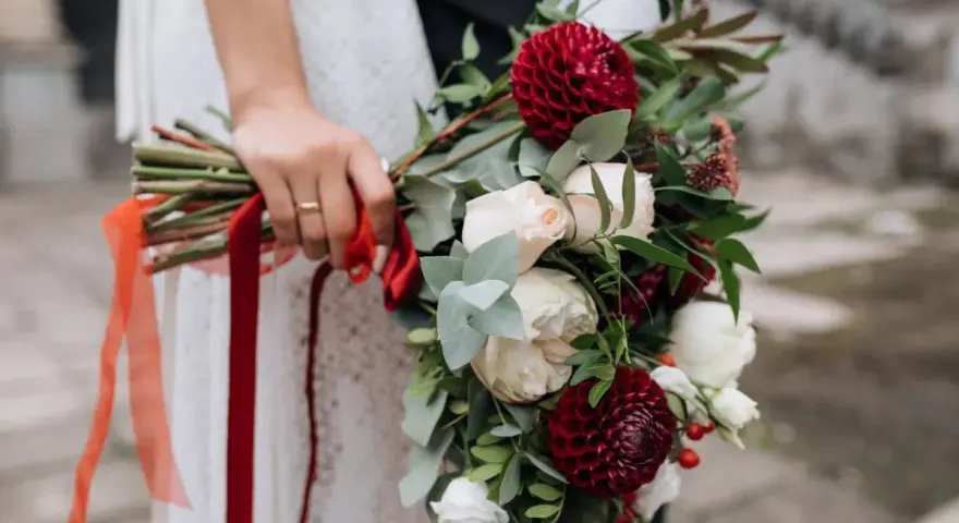 Elegancki bukiet z czerwonych i białych kwiatów, ozdobiony wstążkami, idealny jako kwiaty na ślub w prezencie.