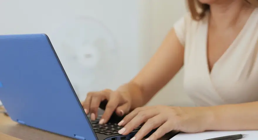 Kobieta pisze na laptopie, tworząc idealny profil. Zastanawiasz się, jakie rzeczy o których kłamiemy na portalach randkowych ukrywa?