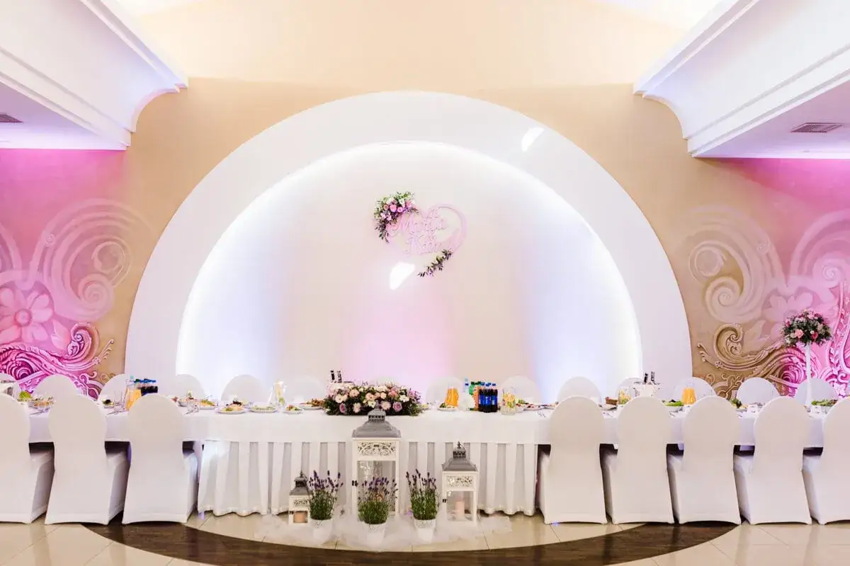 Eleganckie wesele w stylu nowoczesnym z sercem z imionami pary i kwiecistymi dekoracjami.