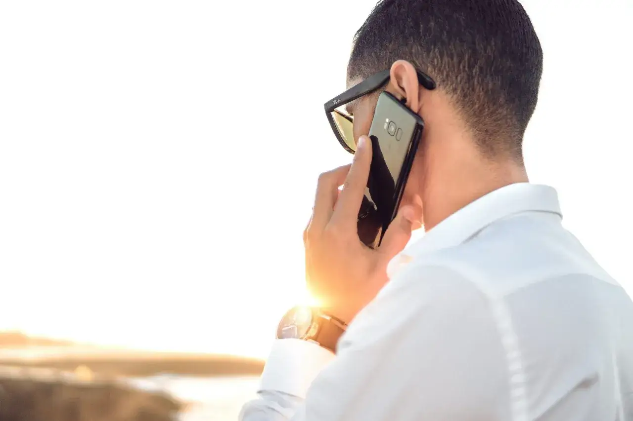 Zastanawiasz się, co napisać do dziewczyny wieczorem? Ten mężczyzna rozmawia przez telefon, być może planuje romantyczny wieczór.